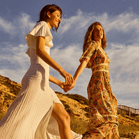 Two women in high-fashion maxi dresses