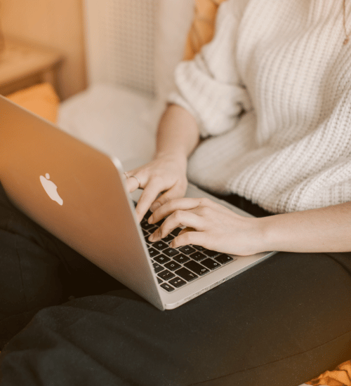 Woman sitting and typing on laptop